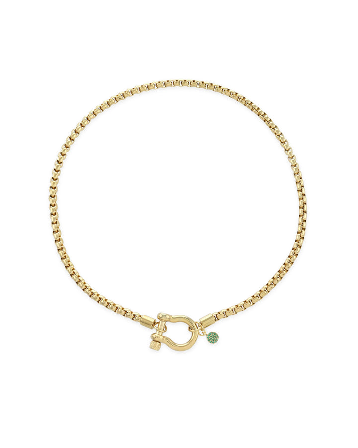 The Herradura Green Necklace, a single gold chain necklace featuring a bold clasp and a small green charm. This sleek and modern piece adds a touch of color and elegance, perfect for layering or wearing alone as a statement accessory.