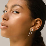 Model wearing one the BAMBOO long earrings which is made of 925 Sterling Silver with a 25 mm long sterling silver and encrusted zirconia. She is also wearing two other long diamond encrusted earring in different styles.