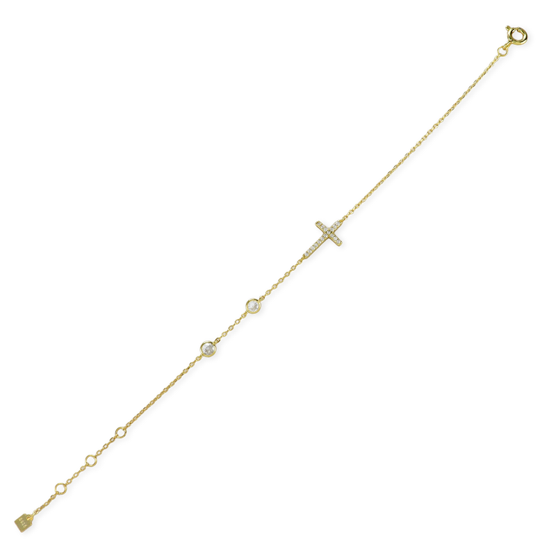 The Fine Cross Bracelet which is a gold bracelet featuring a dainty chain adorned with three shimmering diamonds and a cross charm set with sparkling diamonds.