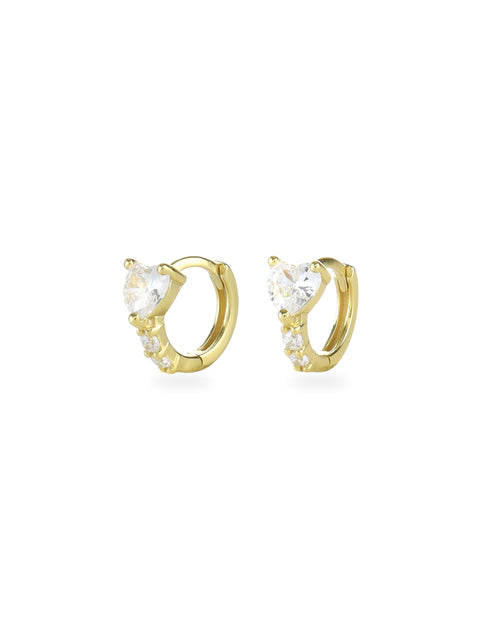 The One Stone Gold Piercing Hoops, which are a pair of gold hoop earrings, feature a central heart-shaped stone with additional sparkling accents along the band.