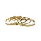 The Queen's Crown Bracelet Stack, a four-piece gold bracelet stack featuring bangles with a variety of accents, including the word "ARTIZAN," emerald accents, and a textured design.
