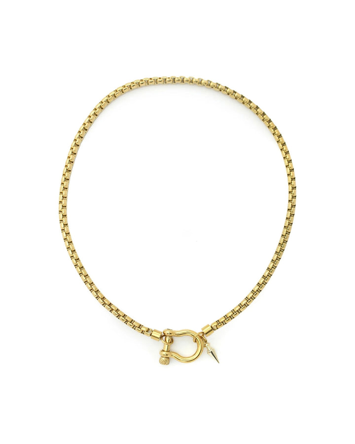 The Herradura Spike Necklace, a gold necklace with a spike charm and a unique horseshoe clasp.
