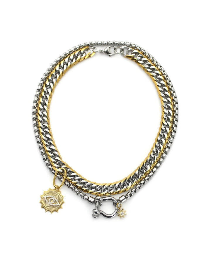 The Herradura Eye Layered Necklace, a bold two-tone necklace featuring dual silver and gold chains with an eye-catching evil eye charm and a sunburst pendant. This statement piece combines chunky layered chains with mystical-inspired charms, perfect for adding an edgy and unique look to any outfit.