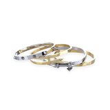 The Spiked Armor Bracelet Stack, a four-piece gold and silver bracelet stack featuring bangles with spike accents, diamond-like stones.