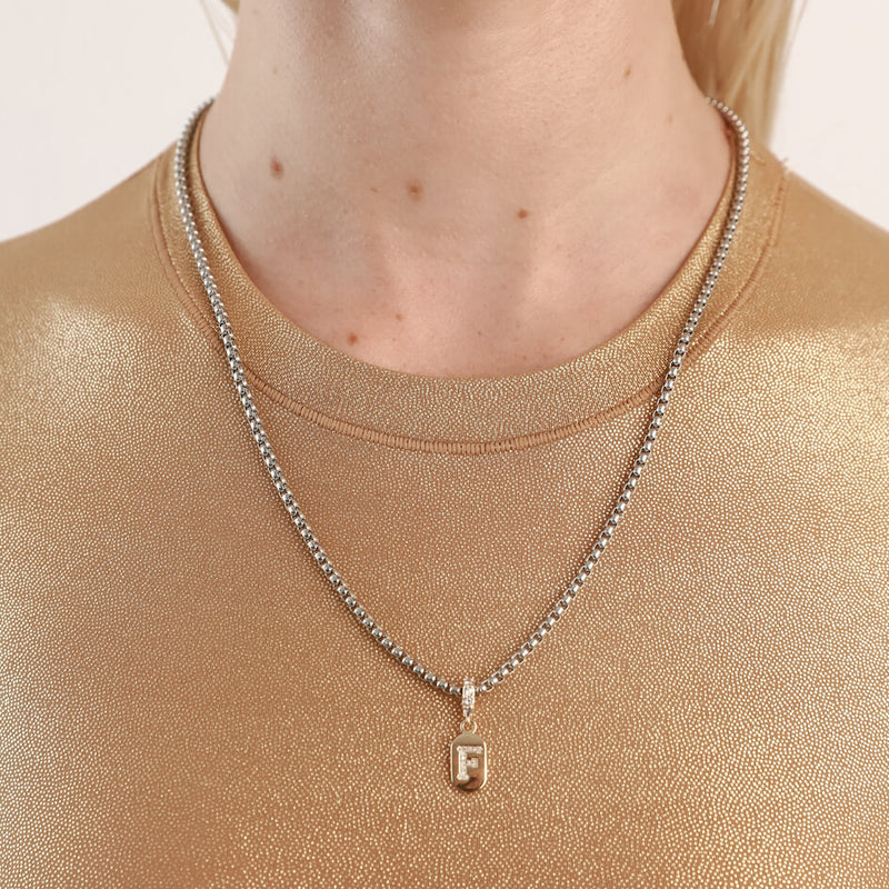 Model wearing the LETTER DAINTY NECKLACE made of Stainless steel chain 1mm wide chain and Gold filled encrusted zirconia letter F initial charm.