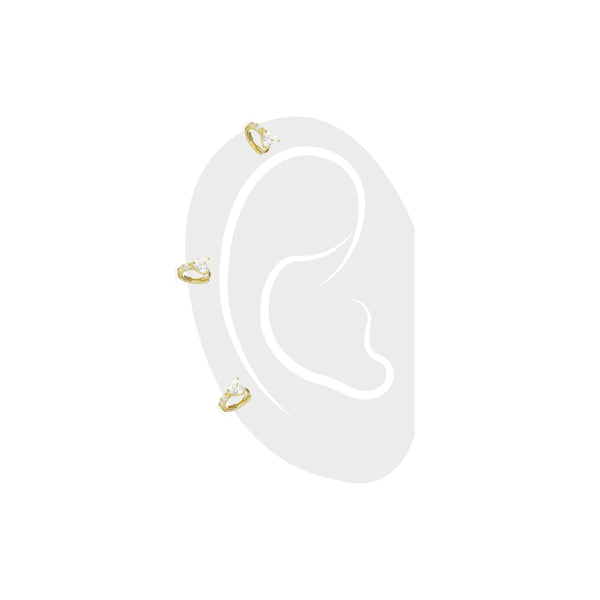 The One Stone Gold Piercing Hoops, which are gold hoop earrings, feature a central heart-shaped stone with additional sparkling accents along the band.