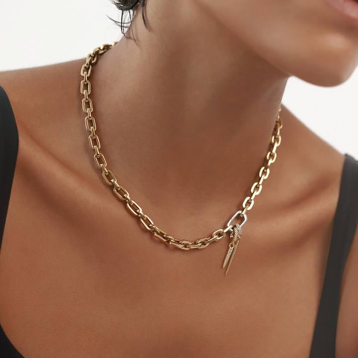 Model wearing The Just Click Needle Puerto, a gold chain with a lobster clasp closure and two charms: a diamond-like encrusted spike and a smaller spike.