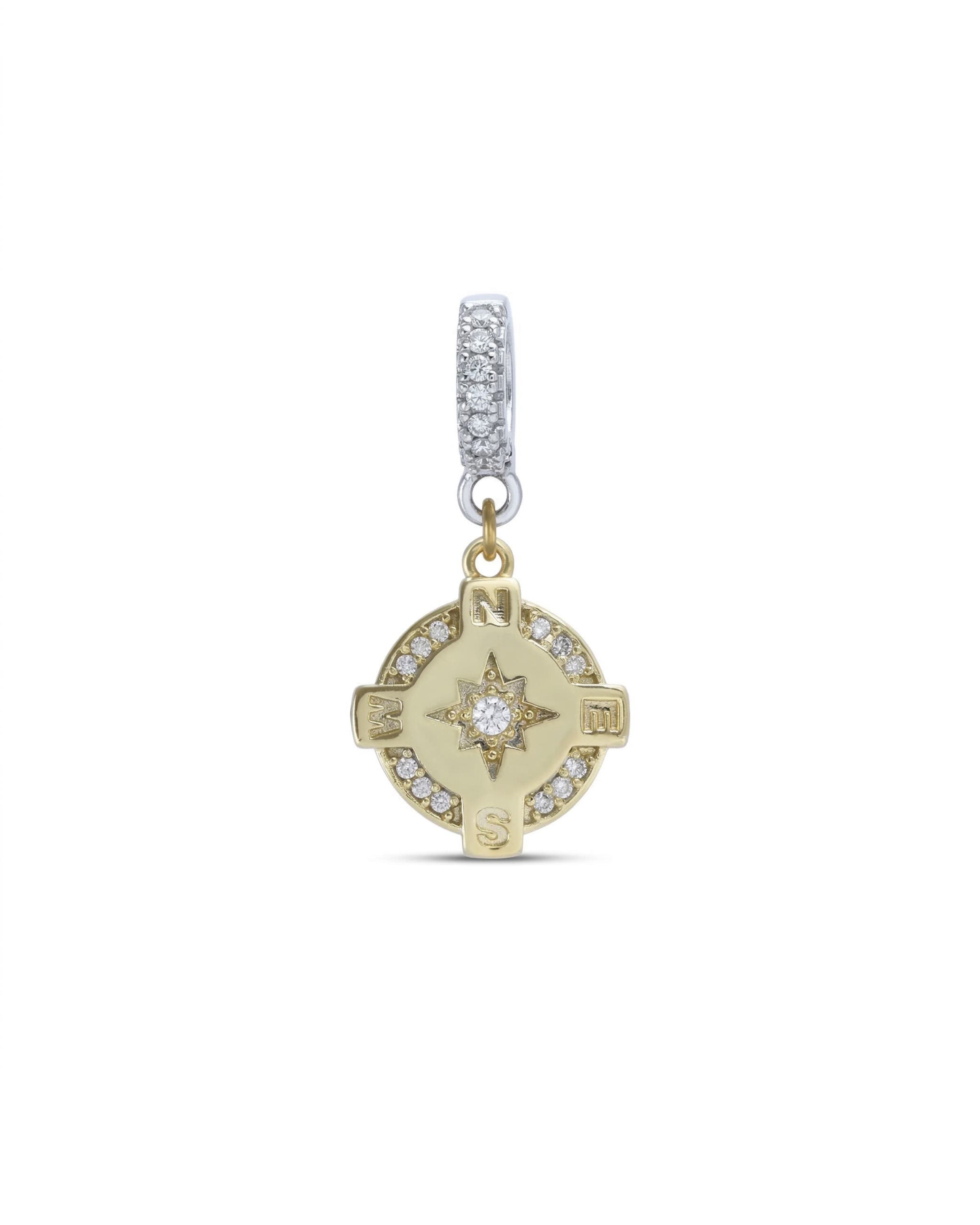The Go North Clip On Charm, a gold compass charm accented with diamond-like stones.
