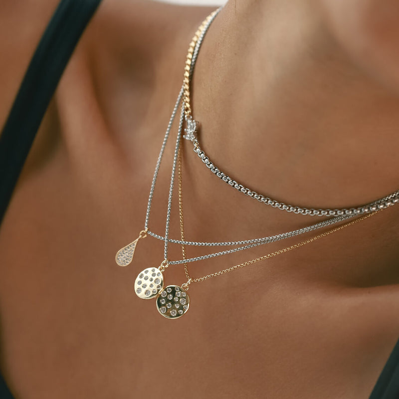 Model wearing the FUSION IRIS NECKLACE, two thin chain with the DALMATIAN BULKY CHARM and the RAINDROP NECKLACE which is made of 1mm wide Stainless steel chain with 18K gold plated sterling silver pave drop charm.