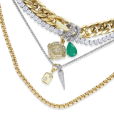 The Just Click Emerald Tennis Necklace Set, a four-piece gold and silver necklace set featuring a variety of chains with diamond-like accents, emerald accents, and a variety of charms.