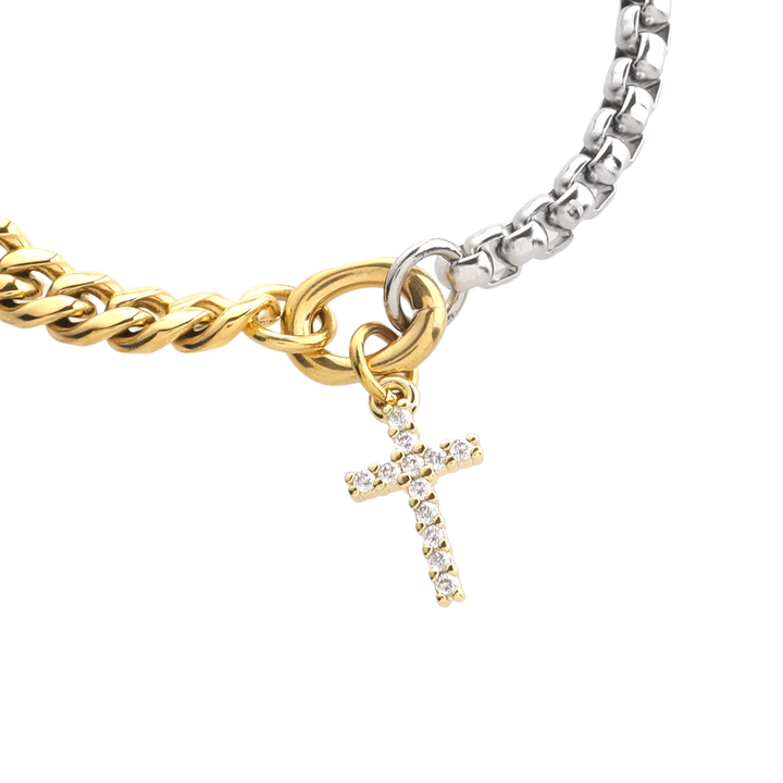 The OPPOSITES ATTRACT CHAIN BRACELET, a two-tone bracelet with half gold Cuban links and half silver box chain, featuring a small cross charm hanging from the center. |||  Cross Charm/MIX