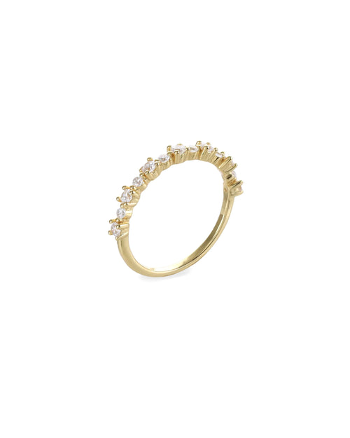 The Crown Ring, which is a single gold ring, features a delicate band adorned with a row of sparkling crystal accents in a crown-like design. This elegant piece is perfect for stacking or wearing alone for a subtle yet luxurious statement. Ideal for adding a touch of sophistication to everyday looks or special occasions.