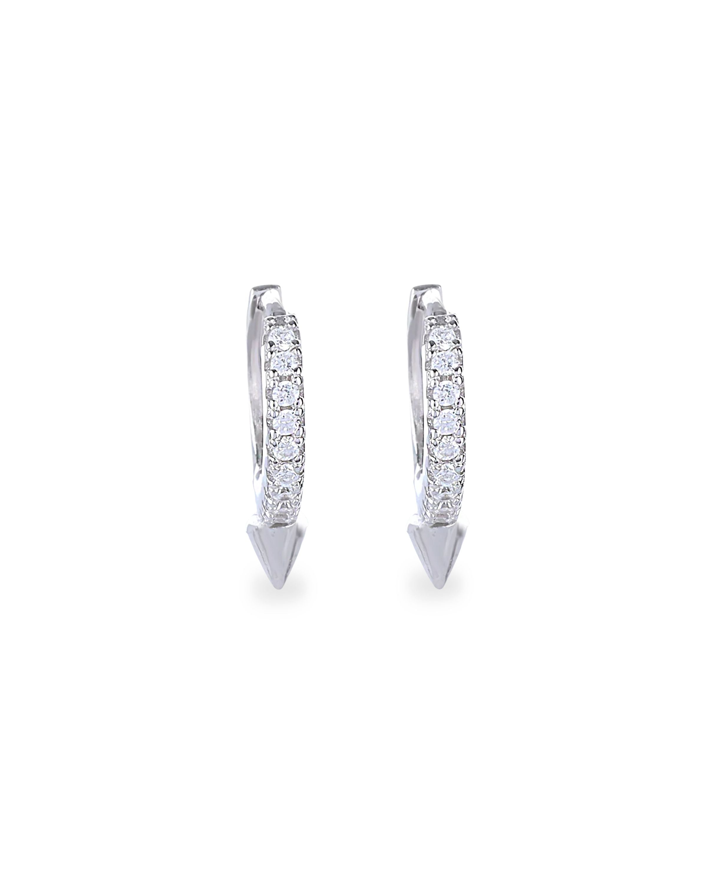 The MINI SHOT HOOP, which is a pair of sleek silver earrings, features a delicate hoop design adorned with sparkling cubic zirconia stones and finished with a pointed charm at the base for a modern edge. Perfect for adding a subtle yet bold statement to any outfit.