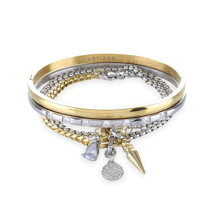 The Mix Gear Bracelet Stack, a four-piece gold and silver bracelet stack featuring two bangles and two chains with a variety of charms, including a teardrop charm, a spike charm, and a disc charm accented with diamond-like stones.