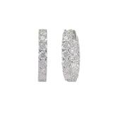 The Wraparound Maxi Huggies, a pair of silver hoop earrings completely encrusted with sparkling cubic zirconia stones.