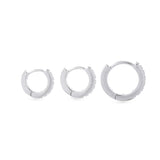 The Mini Clear Huggies, a pair of small silver hoop earrings with sparkling clear cubic zirconia stones.||| SILVER