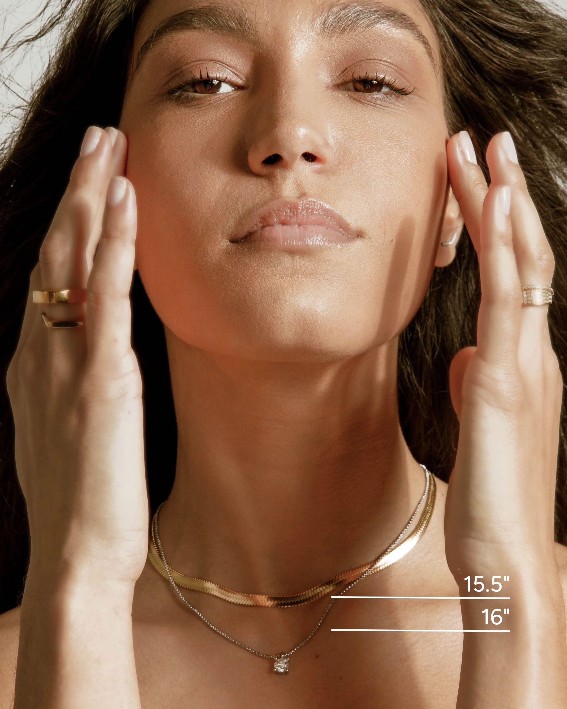 Model wearing The CHIC SNAKE NECKLACE which includes 2 necklaces. A Rhodium-plated stainless steel chain with Solitaire 1ct zirconia and Stainless steel 18k gold plated snake necklace.  She is also wearing the SHAPE STACK RING, SEEDS Ring and another ring filled with cubic zirconia.