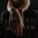 Model wearing the Abuela Ring which is a Gold textured statement ring with diamond accents in a unique wave design.