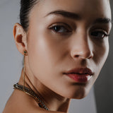 Model wearing the Tennis Earring Chain, a single long gold chain earring with tiny sparkling stones.||| GOLD