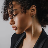 Model wearing 3 Tennis Earring Chains, a long gold chain earring with tiny sparkling stones.||| GOLD