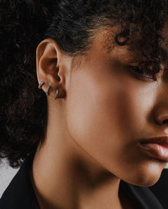 Model wearing the Mini Clear Huggies, a pair of small silver hoop earrings with sparkling clear cubic zirconia stones.||| SILVER