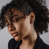 Model wearing three Tennis Earring Chains, a single long silver chain earring with tiny sparkling stones.||| SILVER