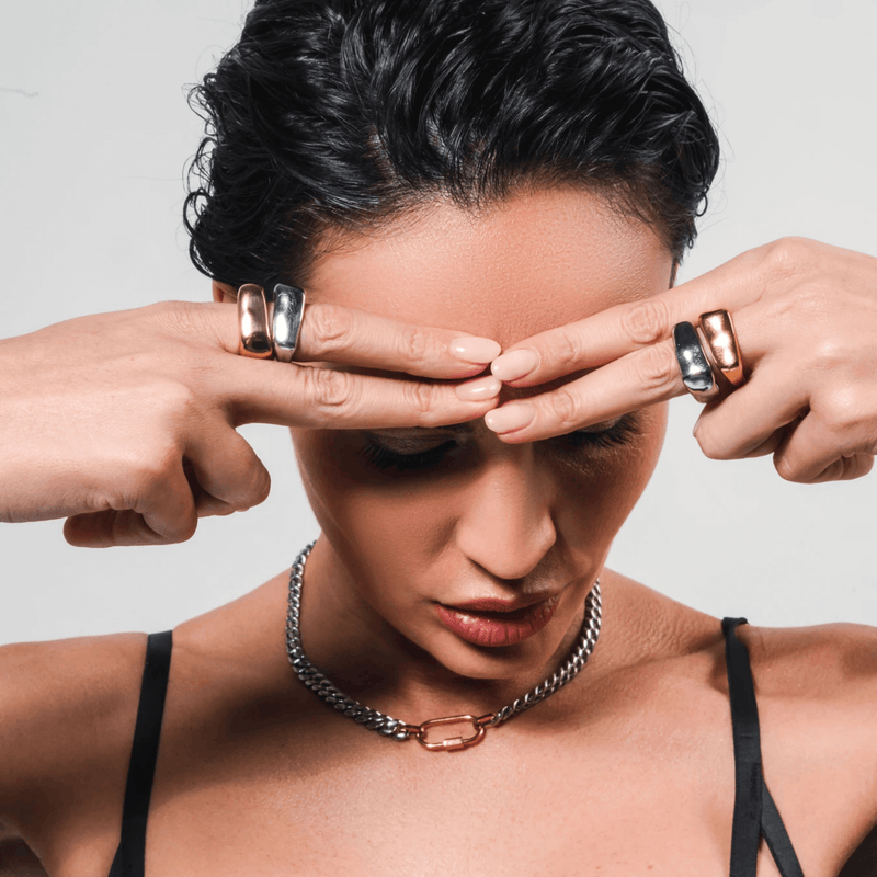 Model wearing HIGH PEAK RING SET in gold and silver paired with the Anne Mix Necklace, featuring a silver chain and gold carabiner, styled with a bold and edgy vibe.