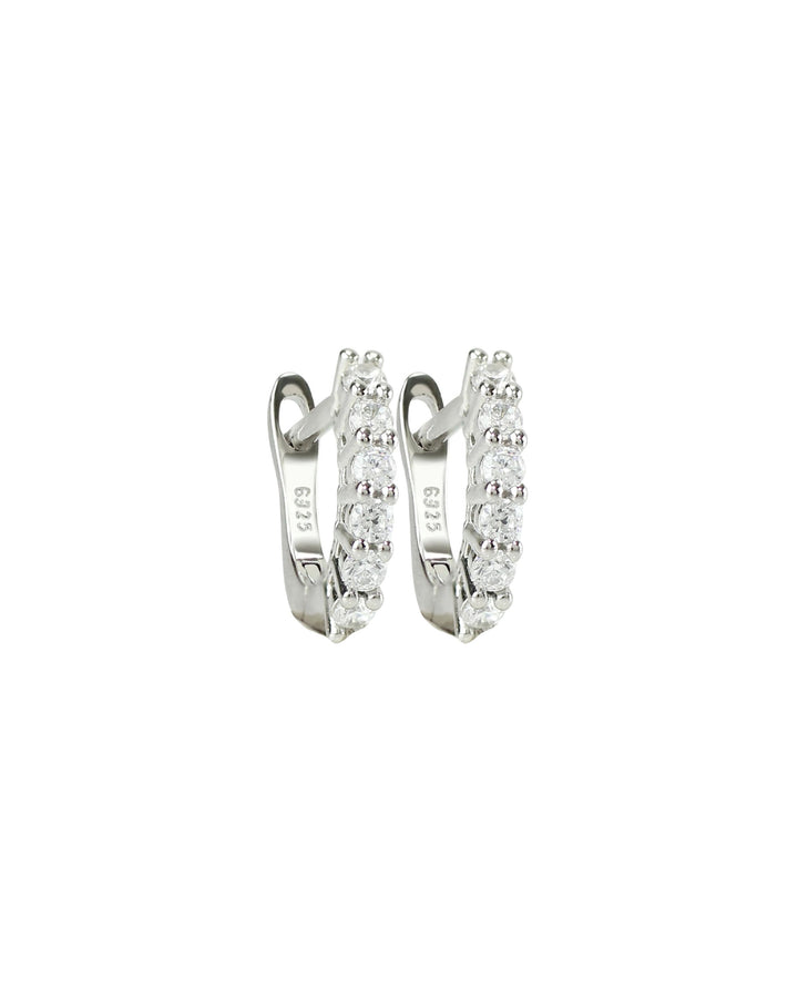 The Prong Hoops, which are a pair of silver hoop earrings, feature a stunning row of sparkling prong-set cubic zirconia stones along the front for a dazzling effect. These elegant hoops are perfect for adding a touch of glamour to any outfit, making them versatile for both everyday wear and special occasions ||| SILVER