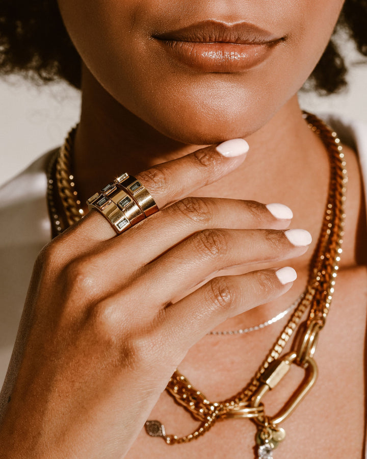 Model wearing three Emerald Rings which are made of 5mm Stainless steel 18k gold plated with 3 emerald zirconia stones encrusted. She is also wearing the Maya layered necklace set. 