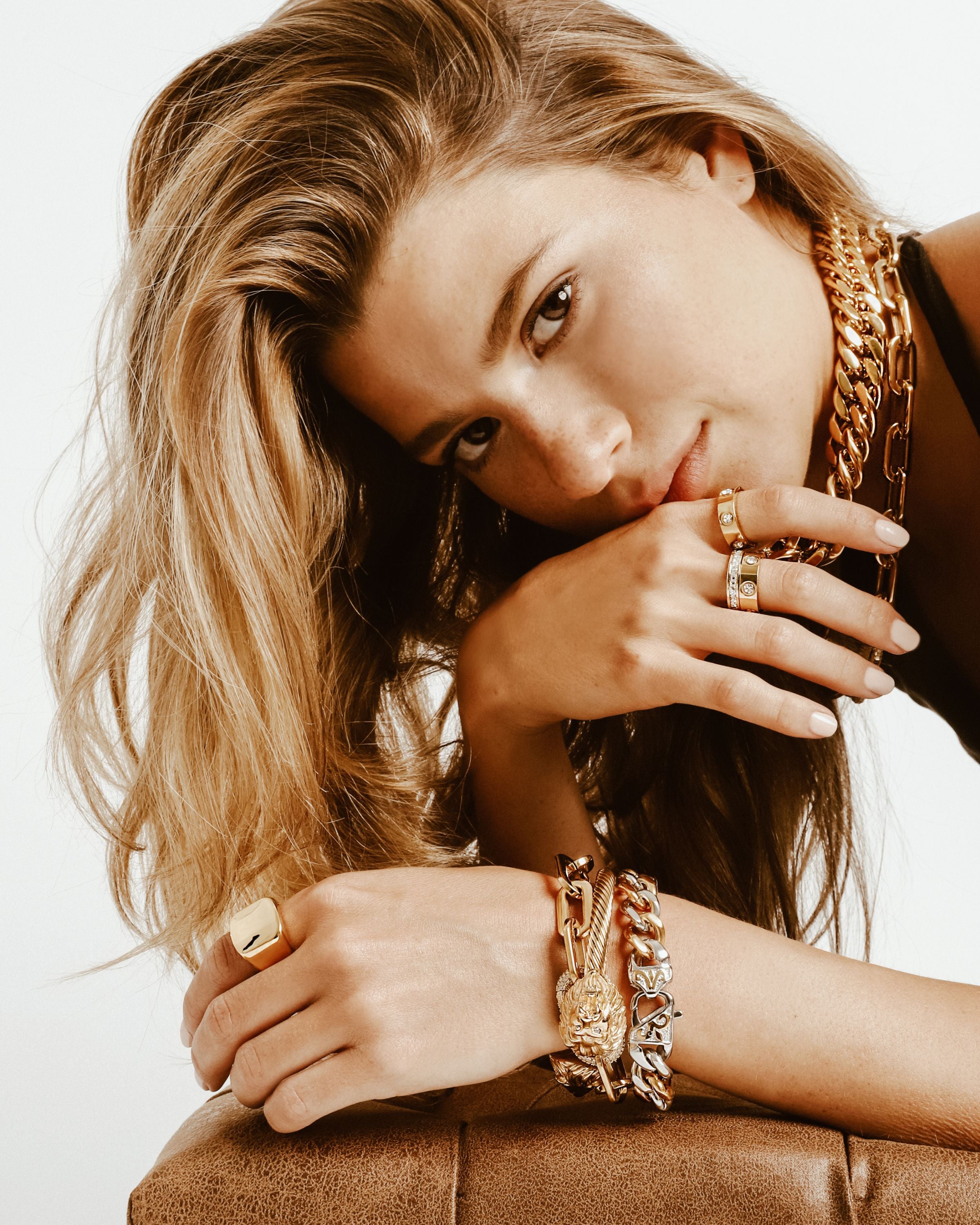 Model wearing a black haltered top accessorised with chain necklaces and bangles and also the Forever Ring Gold which is made of 18k Gold plated stainless steel.