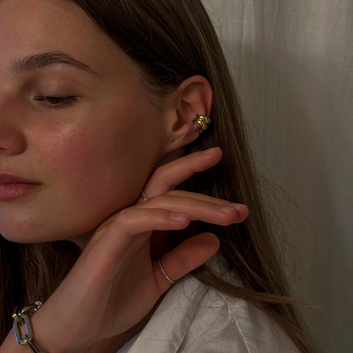 Profile view of a woman wearing layered gold and silver hoop earrings, adding a touch of elegance to a natural look.