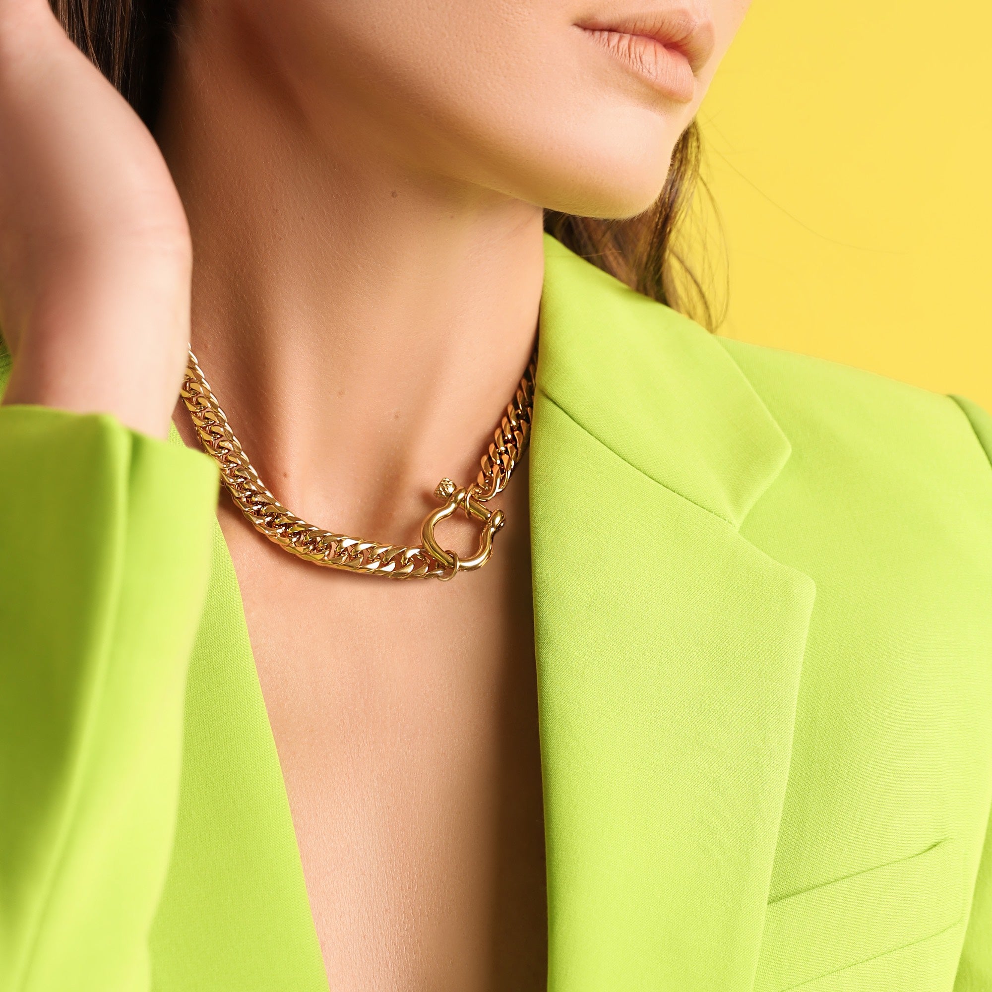 Model wearing the Herradura Tropicana, a bold gold-tone necklace with a sleek chain design and signature Herradura clasp, perfect for any statement look. ||| GOLD