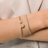 Model wearing the Tennis and the Box Bracelet Set, a two-piece silver bracelet set featuring a diamond-like tennis bracelet and a box chain bracelet with a gold north star charm accented with diamond-like stones.