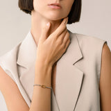 Model wearing the Unique Can Opener Box Chain Bracelet featuring a distinctive gold link design and a secure clasp ||| GOLD