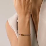Model wearing the Unique Can Opener Box Chain Bracelet featuring a distinctive gold link design and a secure clasp ||| GOLD