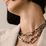 Model  wearing two Carabiner Square Puerto Necklaces, which is a silver chain necklace featuring a unique silver carabiner clasp. ||| SILVER
