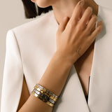 The Triangle Stack, which is a set of five elegant bangles, features a blend of gold and silver tones with modern geometric accents. This versatile bracelet stack includes minimalist designs with subtle embellishments, perfect for layering or wearing individually for a chic look.