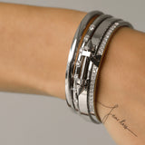 Model wearing The ARROW STACK, a stunning silver bangle set featuring 4 bracelet stack with intricate arrowhead details and sparkling diamonds. 
