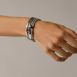 Model wearing The ARROW STACK, a stunning silver bangle set featuring 4 bracelet stack with intricate arrowhead details and sparkling diamonds. 