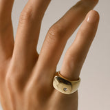 Model wearing the Y Punto Pinky Ring, a gold pinky ring with a minimalist design and a single cubic zirconia stone.