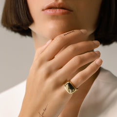Model wearing the Y Punto Pinky Ring, a gold pinky ring with a minimalist design and a single cubic zirconia stone.