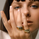 Model wearing the Madness Ring Stack which includes the Y Punto Pinky Ring, a gold pinky ring with a minimalist design and a single cubic zirconia stone and stack of accordion and triangle ring.