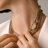 Model wearing the Carabiner Necklace Set, a three-piece gold and silver necklace set featuring Cuban link chains and a carabiner clasp.