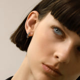 Model wearing one Eternity Emerald Hoops, a silver hoop featuring emerald accents.
