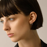 Model wearing the Touch Spike Hoop, a silver hoop earring with a unique spike design and accents of sparkling cubic zirconia stones.