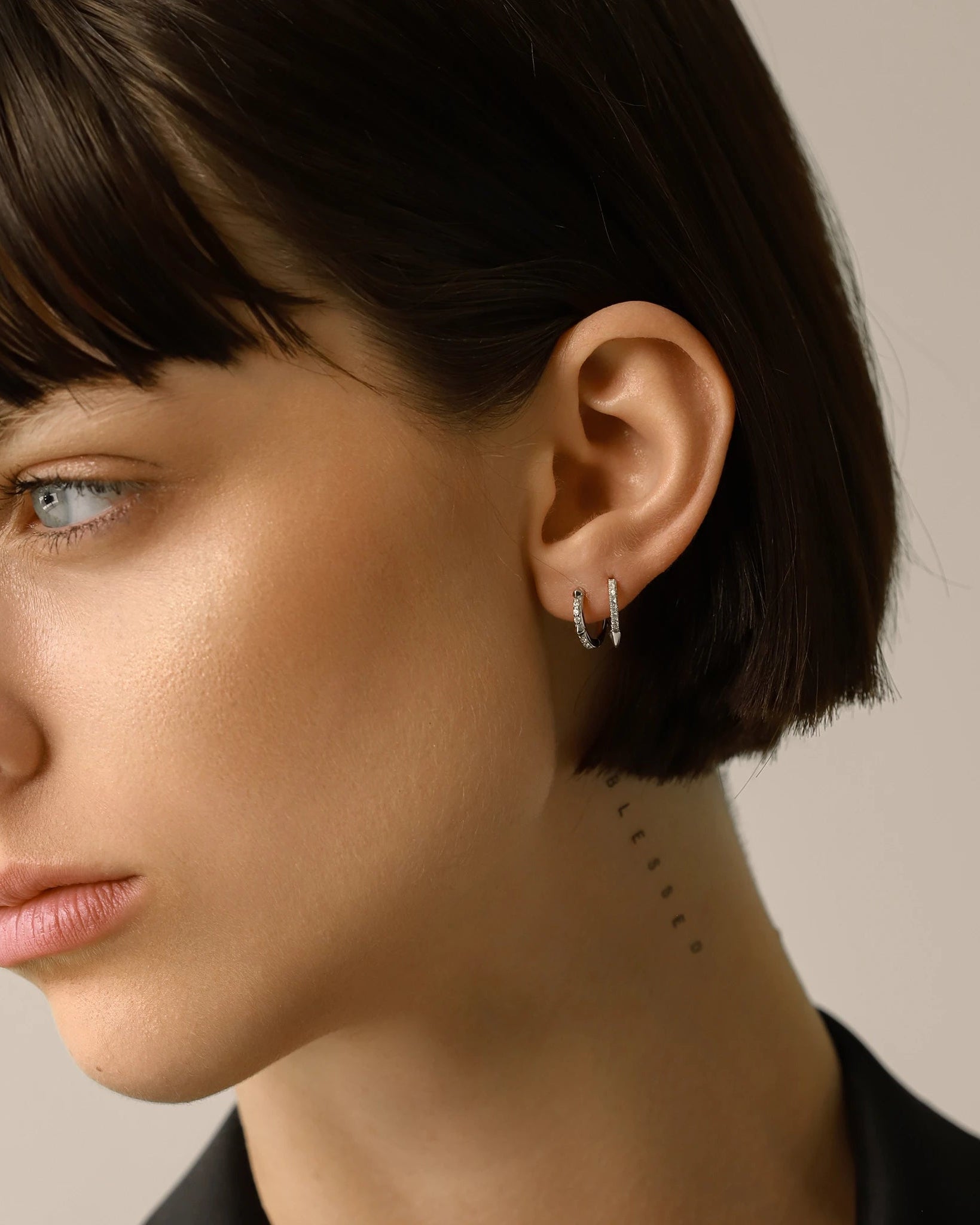 Model wearing the Touch Spike Hoop, a silver hoop earring with a unique spike design and accents of sparkling cubic zirconia stones.