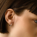 Model wearing the Touch Spike Hoop, a silver hoop earring with a unique spike design and accents of sparkling cubic zirconia stones.