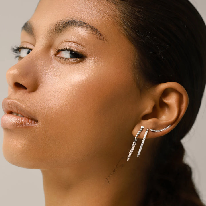 The DRAGON-FLY SINGLE CLIMBER EARRING, which is a single silver ear climber, features a sleek curved design with dazzling stones that elegantly hug the ear. Perfect for adding a modern, minimalist sparkle to your ear stack or wearing as a standout solo piece.
