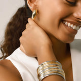 The Bagel Hoop, which is a single-piece gold earring, showcases a bold, rounded shape reminiscent of a bagel, offering a modern and statement-making touch to elevate any outfit with its sleek and polished finish.