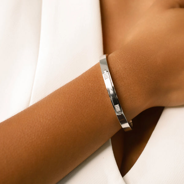 Model wearing the Arrow Bangle, a silver bangle with diamond-like accents.